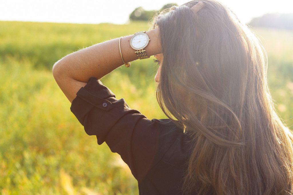 girl holding head with watch hand